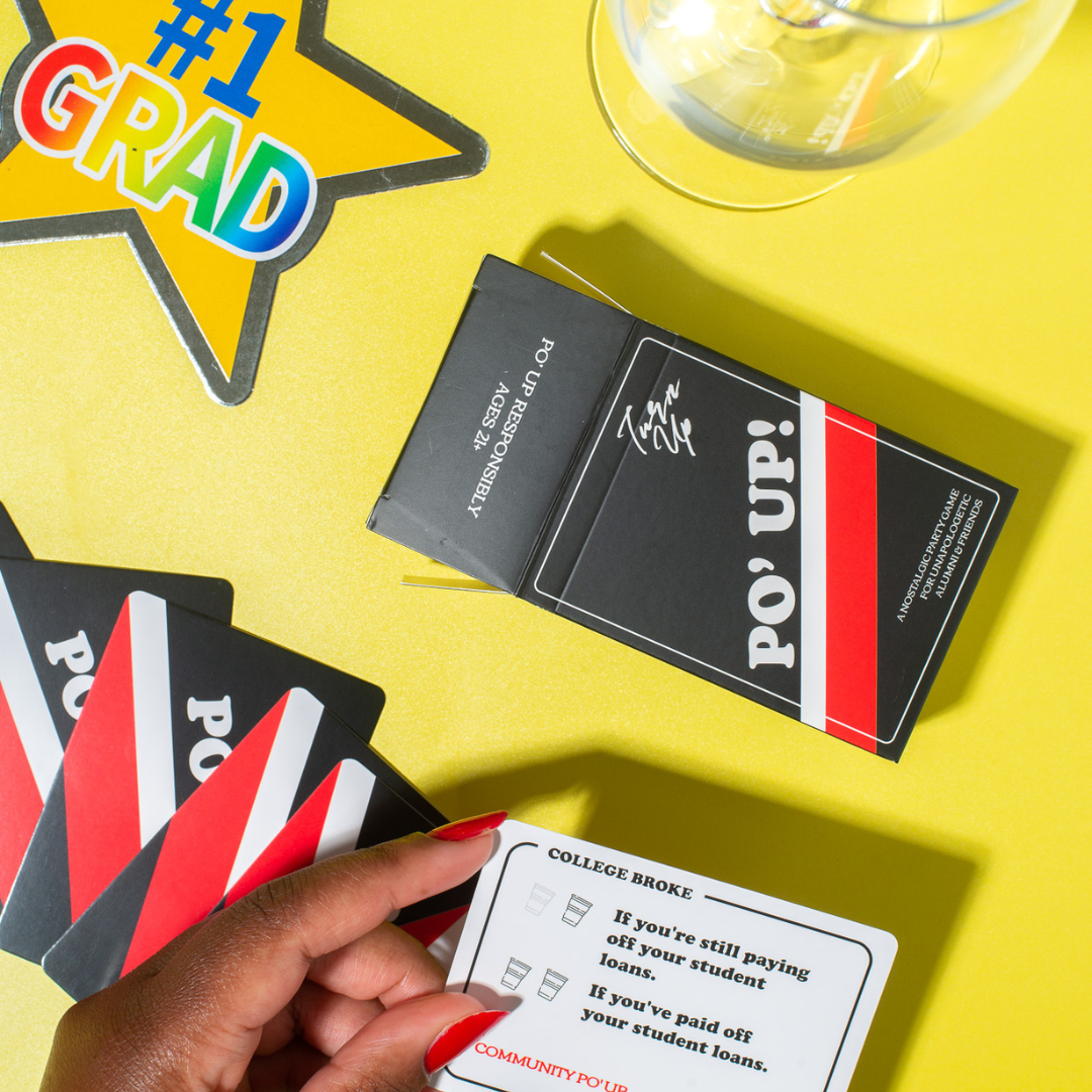 PO' UP! Card Game box displayed on a yellow backdrop next to a "#1 grad" star and a glass of wine.